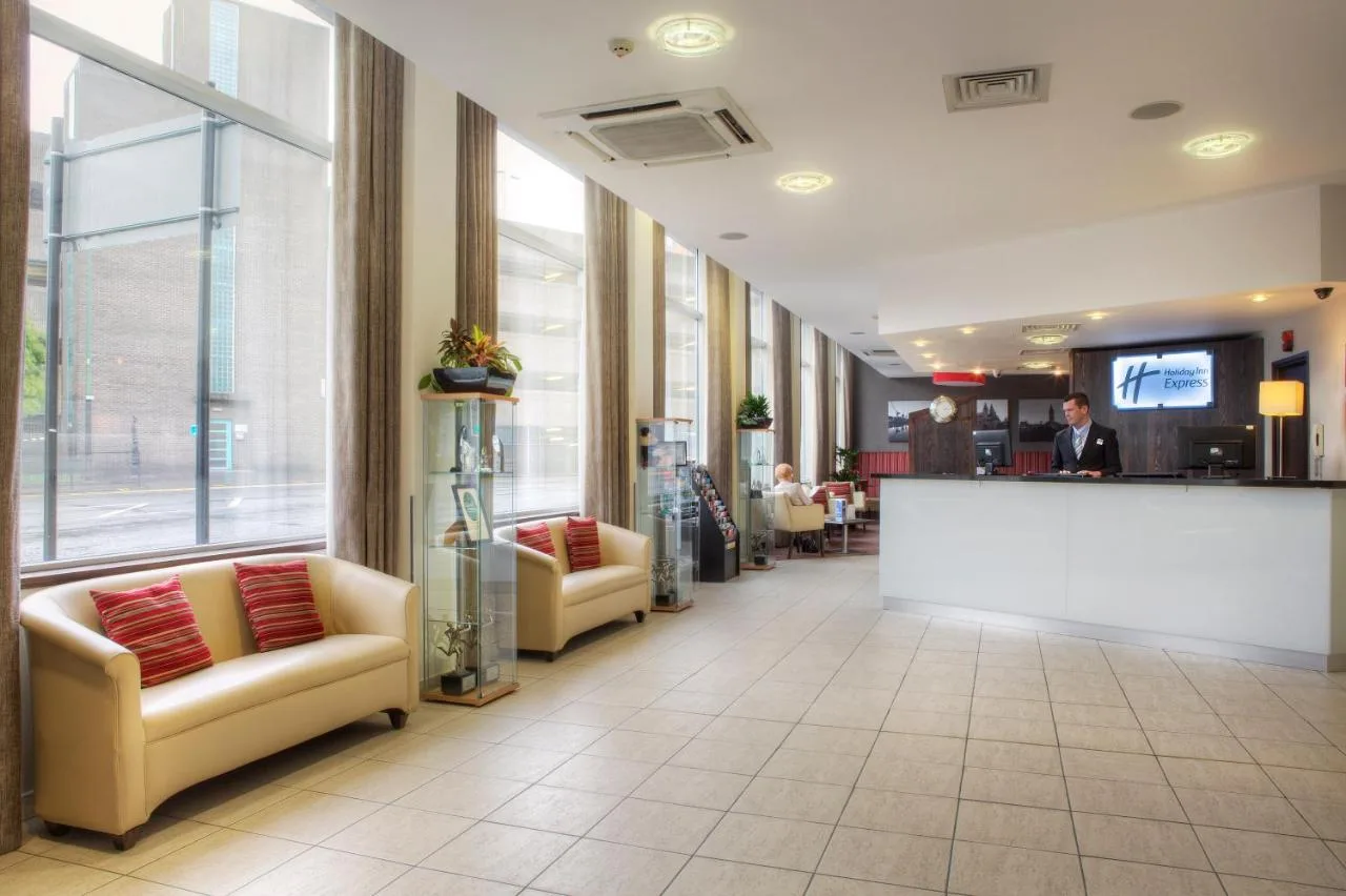 a lobby with couches and a counter in a hospital at Holiday Inn Express Glasgow City Theatreland by IHG in Glasgow