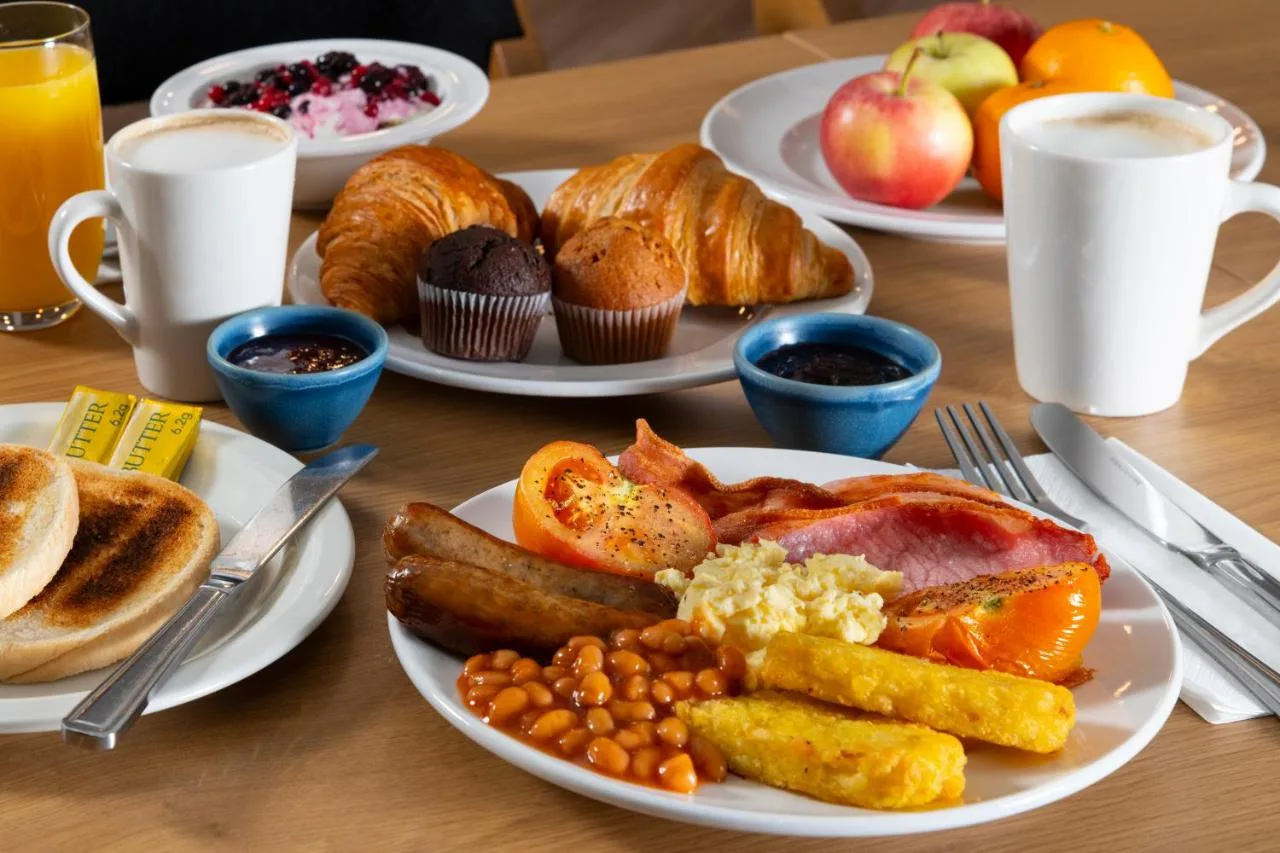 a table with plates of breakfast food on it at Holiday Inn Express Glasgow City Theatreland by IHG in Glasgow