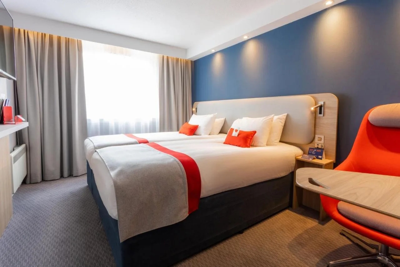 a hotel room with a bed and a red chair at Holiday Inn Express Glasgow City Theatreland by IHG in Glasgow