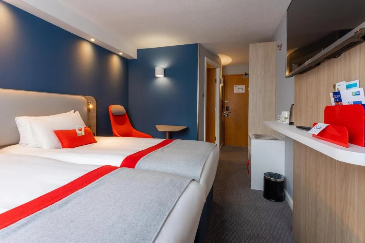 a hotel room with a bed with red accents at Holiday Inn Express Glasgow City Theatreland by IHG in Glasgow