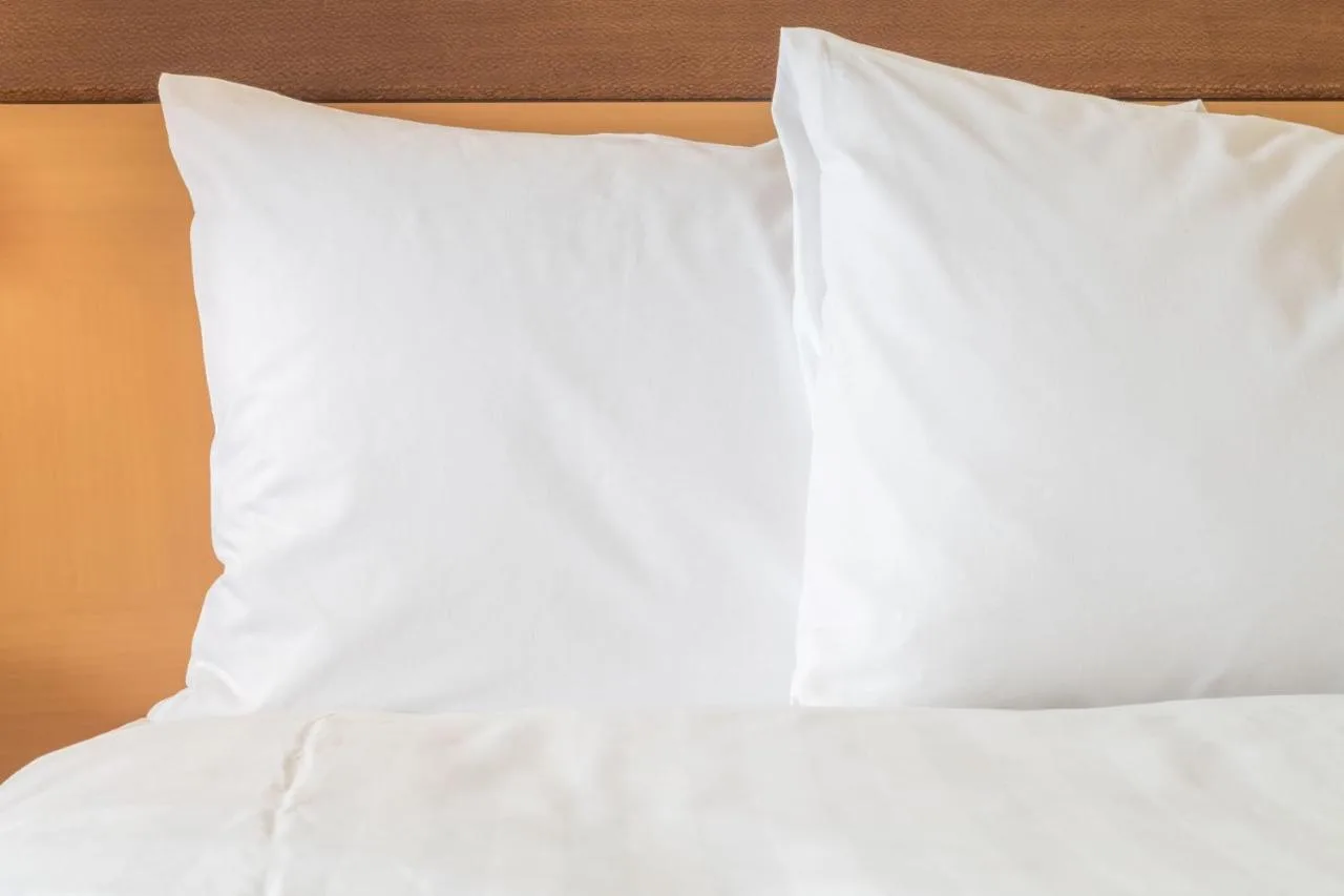 a bed with white sheets and pillows on it at Holiday Inn Express Glasgow City Theatreland by IHG in Glasgow